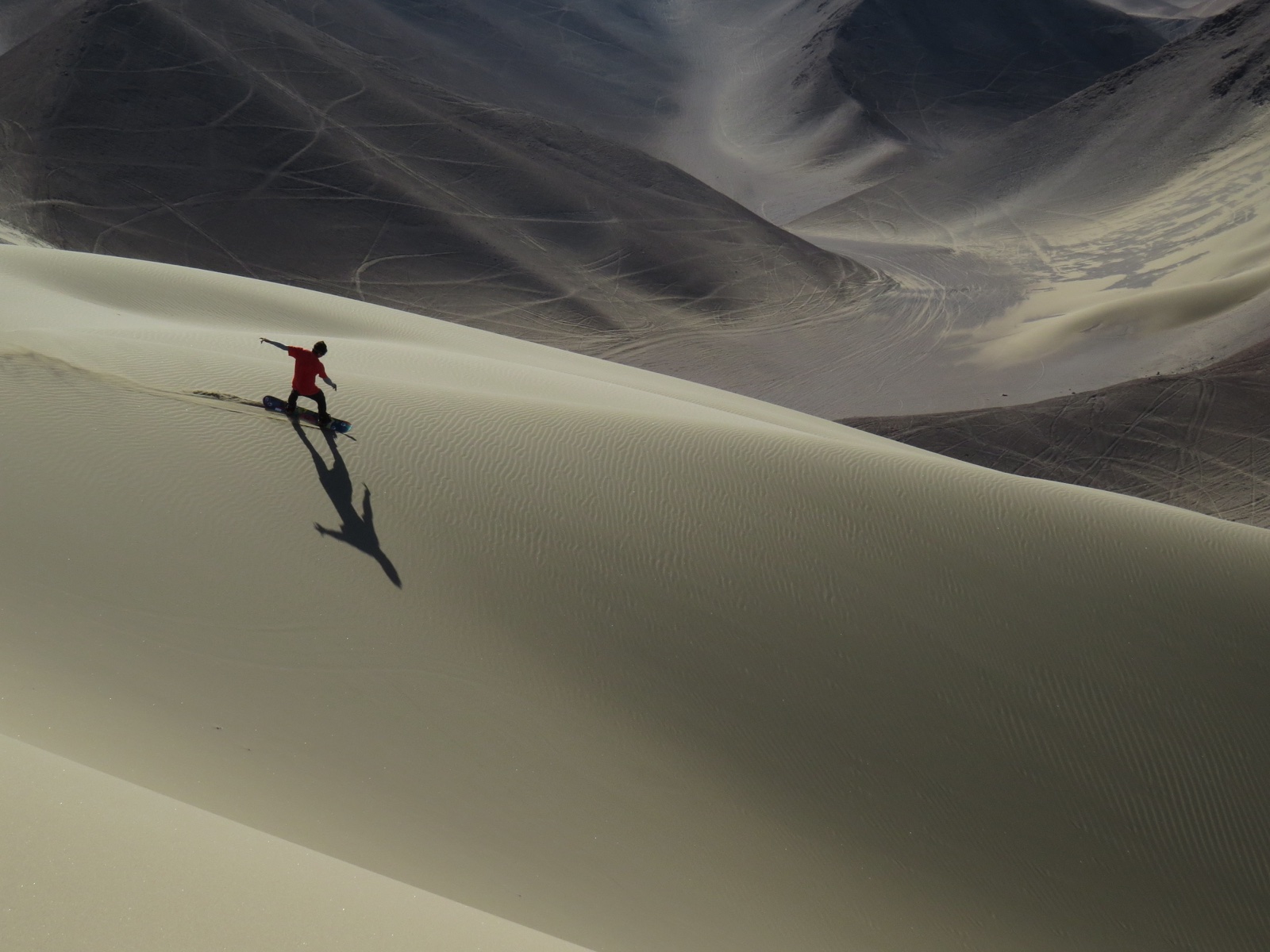 Deportista practicando sandboarding en las dunas de Iquique